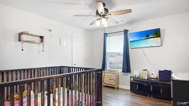 bedroom featuring baseboards, wood finished floors, and a ceiling fan