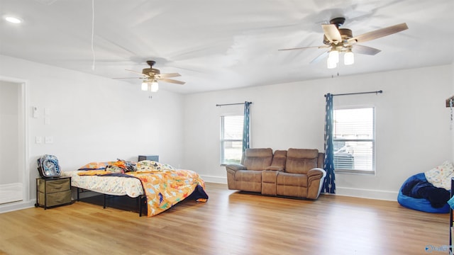 bedroom with baseboards, wood finished floors, and a ceiling fan