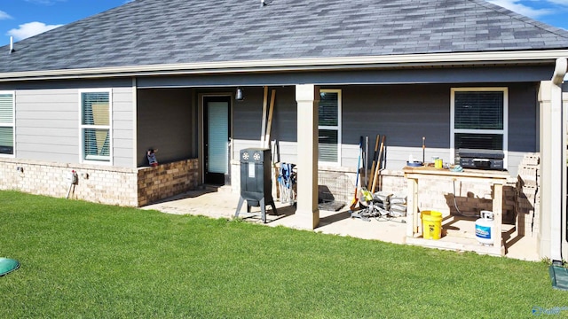 rear view of property with a lawn and a shingled roof