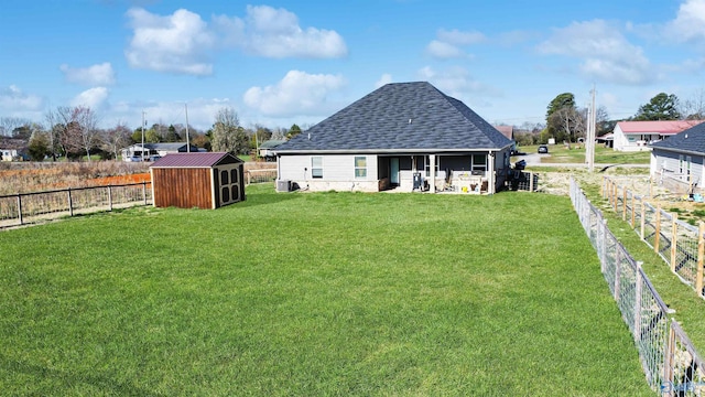 view of yard with central AC, a storage shed, an outdoor structure, and a fenced backyard