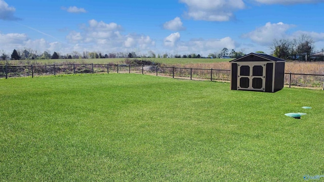 view of yard featuring an outbuilding, fence, a rural view, and a storage shed