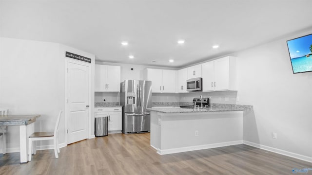 kitchen with white cabinetry, light wood-style flooring, a peninsula, and appliances with stainless steel finishes