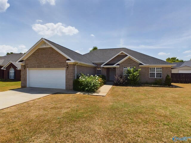 ranch-style home with a garage and a front lawn