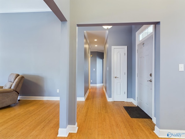 hall with light wood-type flooring and baseboards