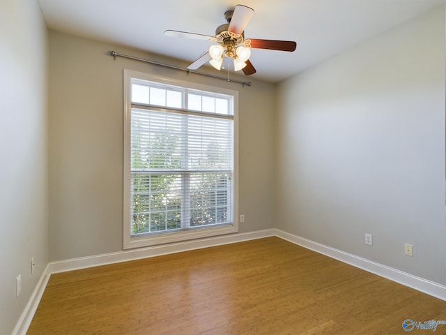 spare room with ceiling fan, baseboards, and wood finished floors