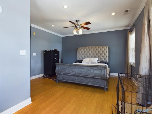 bedroom with light wood-style floors, ornamental molding, and baseboards