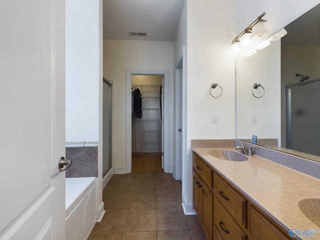 bathroom featuring a stall shower, tile patterned flooring, visible vents, and a sink