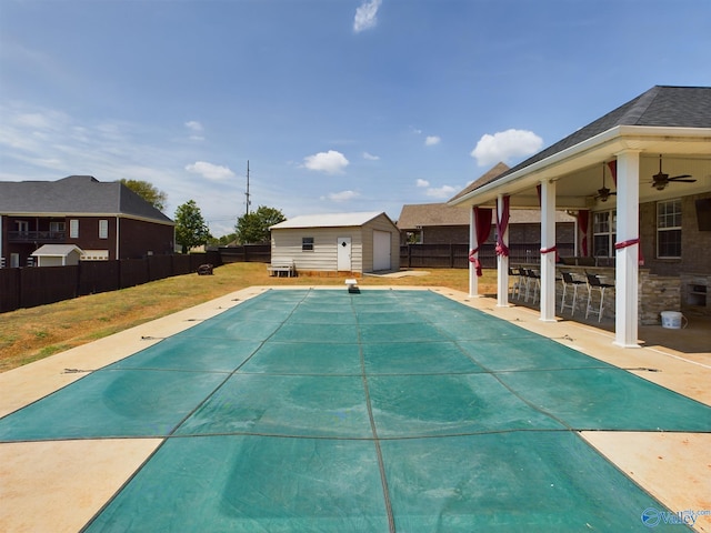 view of pool with an outbuilding, outdoor dry bar, a patio area, and a fenced backyard