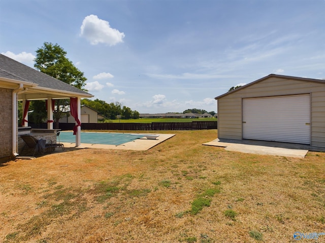 view of yard with fence, a patio, and an outdoor structure