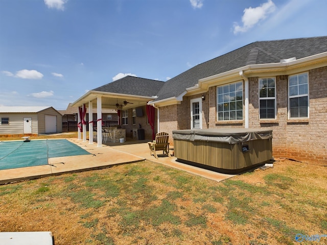 rear view of house featuring a patio area, a hot tub, a shingled roof, and a ceiling fan