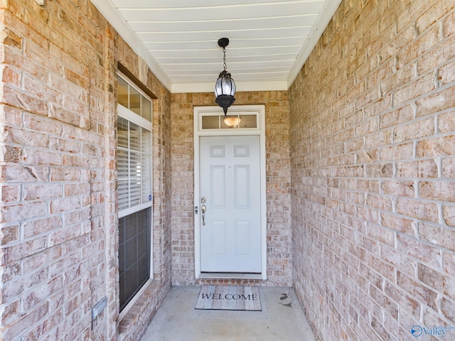 view of exterior entry featuring brick siding