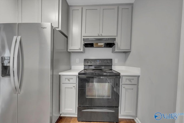 kitchen featuring stainless steel fridge with ice dispenser, black electric range oven, gray cabinets, light countertops, and under cabinet range hood