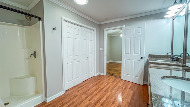 bathroom featuring walk in shower, vanity, crown molding, and hardwood / wood-style flooring