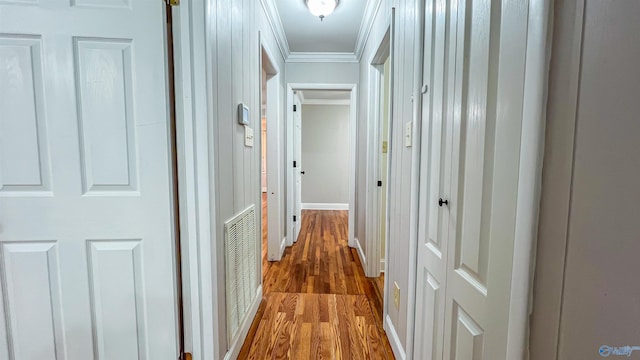 corridor with crown molding and hardwood / wood-style flooring