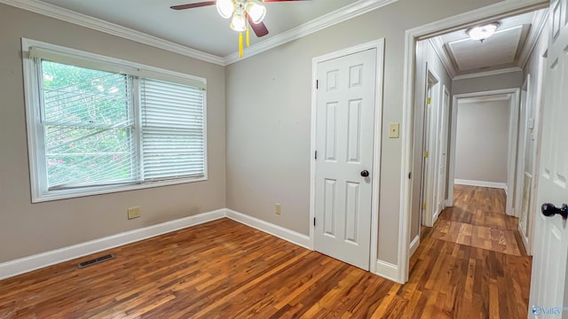 unfurnished bedroom featuring multiple windows, crown molding, hardwood / wood-style flooring, and ceiling fan