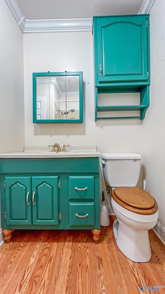 bathroom with vanity, hardwood / wood-style floors, ornamental molding, and toilet