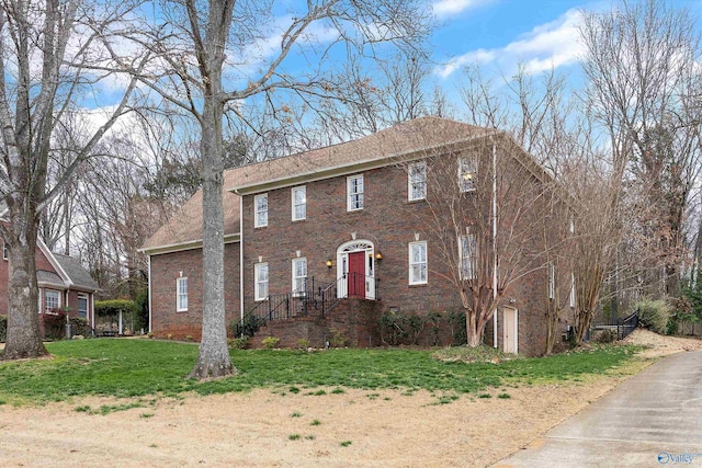 view of front of home with a front yard and brick siding