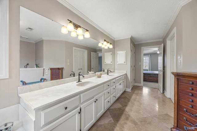 bathroom with double vanity, crown molding, visible vents, and a sink