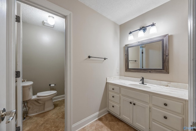 bathroom featuring baseboards, a textured ceiling, toilet, and vanity