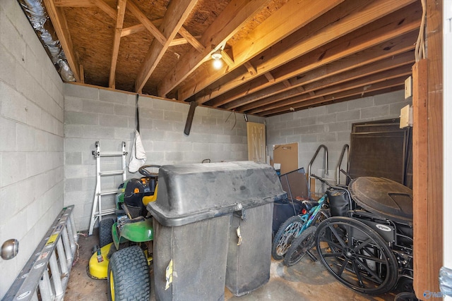 basement featuring a garage and concrete block wall