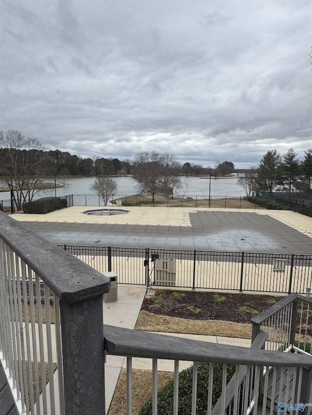 exterior space with a water view and fence