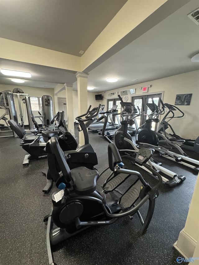 gym featuring a wealth of natural light, decorative columns, and visible vents