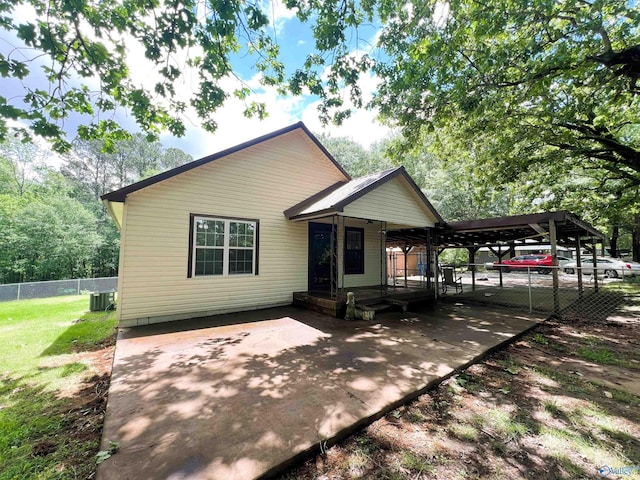 view of front of house featuring central air condition unit and an attached carport