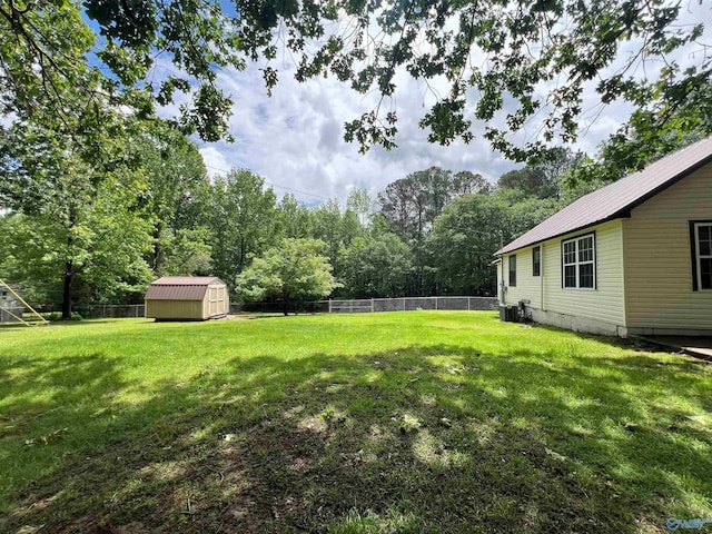 view of yard with a storage shed, an outbuilding, and central AC