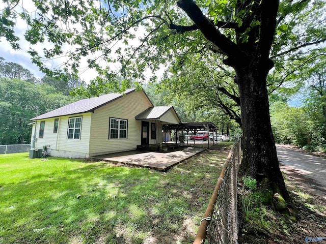 back of house featuring cooling unit, metal roof, and a patio area