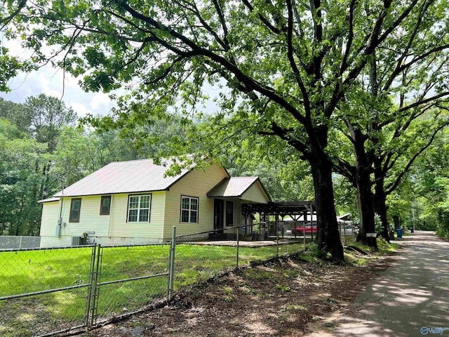 ranch-style home featuring a gate, metal roof, and central AC