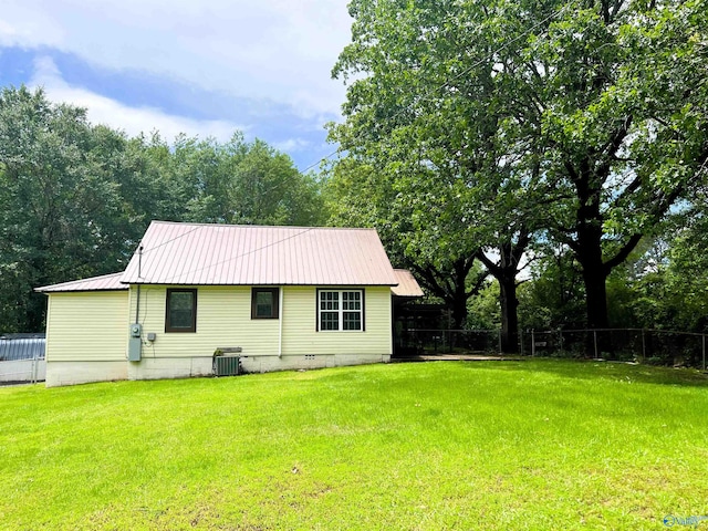 rear view of property featuring metal roof and central AC
