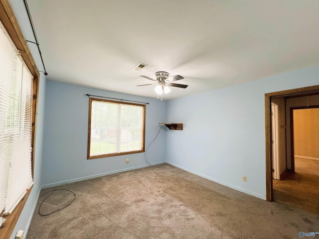 carpeted spare room with a ceiling fan, plenty of natural light, and baseboards