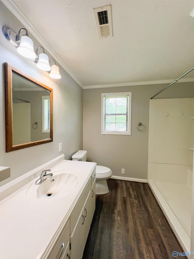 full bath featuring wood finished floors, toilet, vanity, a shower, and ornamental molding