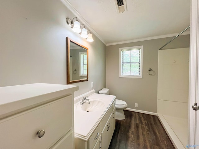 bathroom with vanity, toilet, crown molding, wood finished floors, and a shower