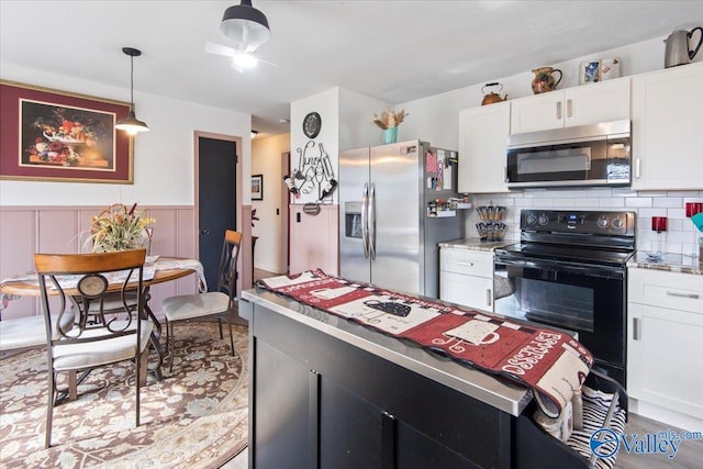 kitchen featuring pendant lighting, backsplash, stainless steel appliances, and white cabinets