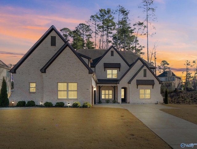 french country inspired facade featuring a yard