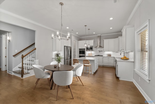 dining space featuring a notable chandelier, dark hardwood / wood-style flooring, ornamental molding, and sink