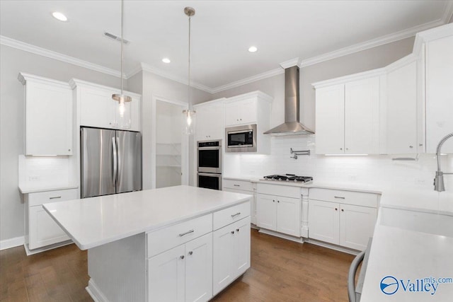 kitchen featuring wall chimney exhaust hood, dark hardwood / wood-style floors, appliances with stainless steel finishes, tasteful backsplash, and white cabinetry