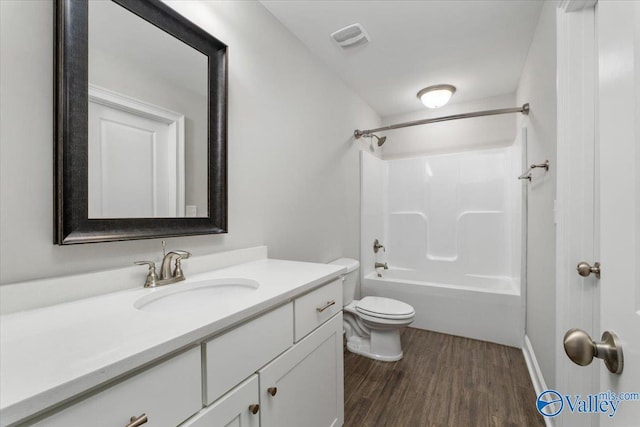 full bathroom featuring hardwood / wood-style floors, vanity,  shower combination, and toilet