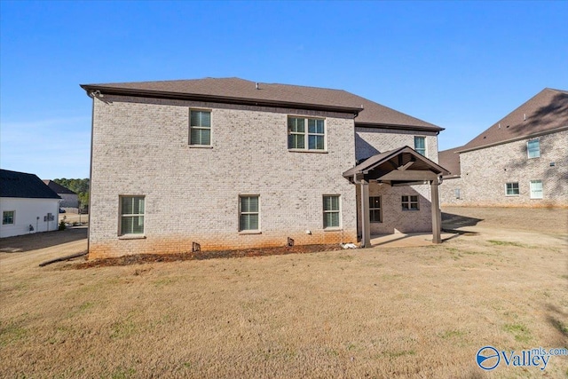 rear view of house featuring a lawn