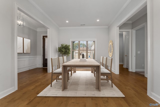 dining space featuring an inviting chandelier, light hardwood / wood-style flooring, and ornamental molding