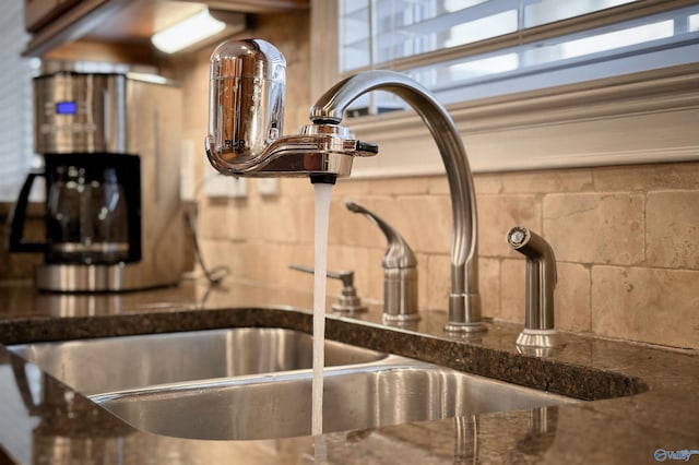 interior details featuring sink and dark stone countertops