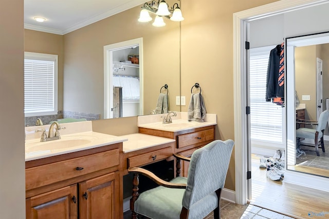 bathroom with tile patterned floors, vanity, crown molding, and a chandelier