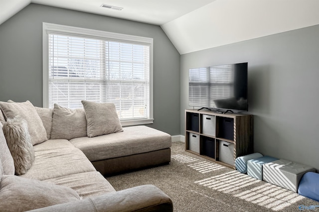 carpeted living room with plenty of natural light and vaulted ceiling