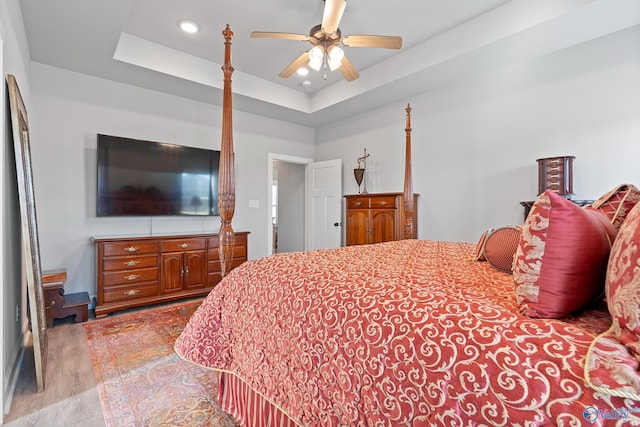 bedroom featuring recessed lighting, a raised ceiling, wood finished floors, and ceiling fan