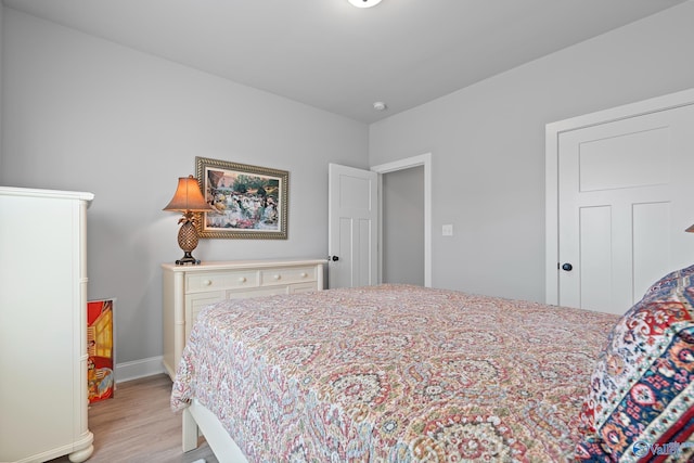 bedroom featuring baseboards and light wood finished floors