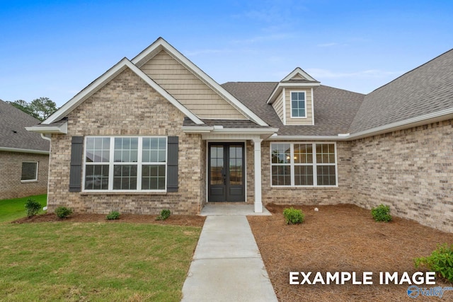 craftsman-style home with a front lawn and french doors