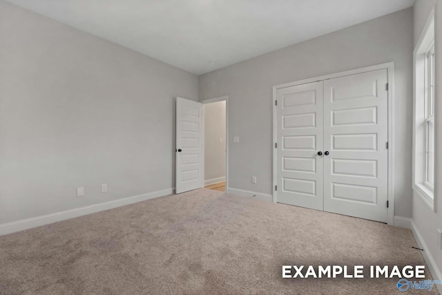 unfurnished bedroom featuring a closet, carpet flooring, and baseboards