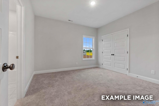 unfurnished bedroom featuring carpet flooring, visible vents, and baseboards
