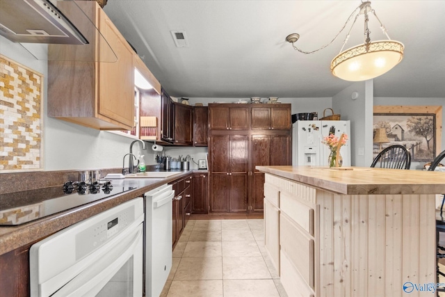 kitchen featuring white appliances, light tile patterned flooring, butcher block counters, a kitchen breakfast bar, and hanging light fixtures